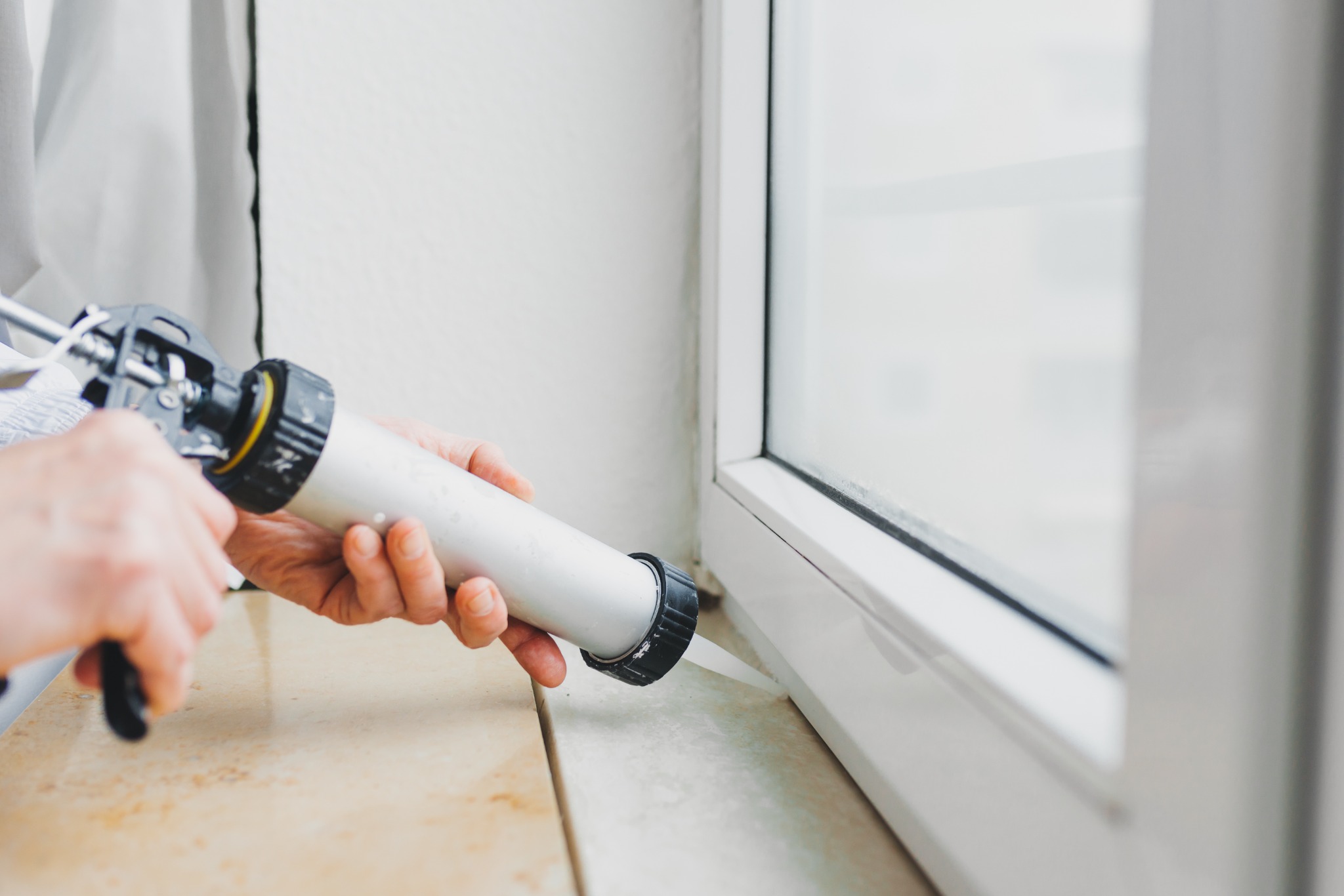 Professional sealing being applied around a window